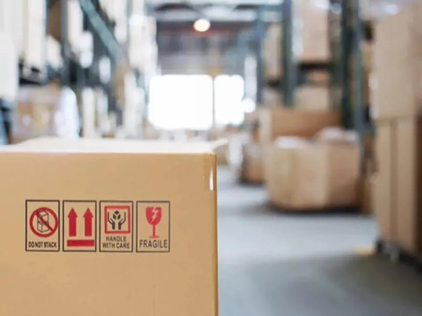 Cardboard box with do not stack, handle with care, and fragile symbols in warehouse